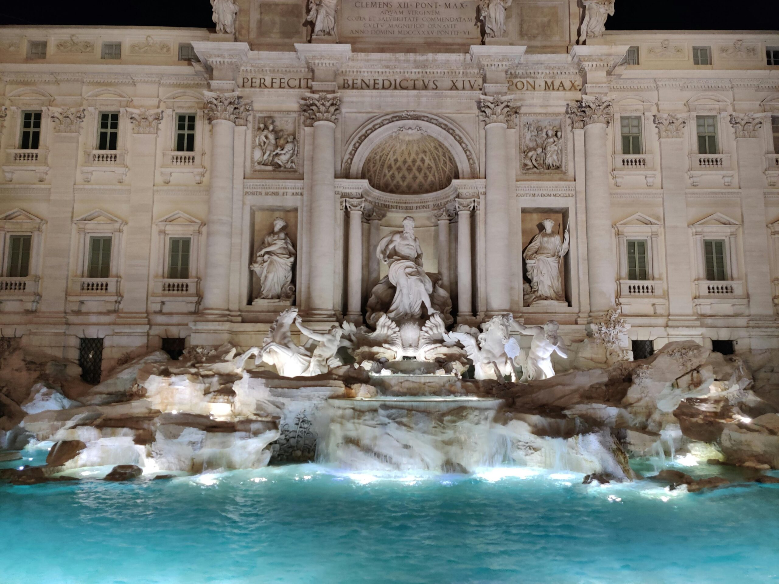 Nighttime photo of Trevi Fountain, Rome's iconic monument, beautifully illuminated.